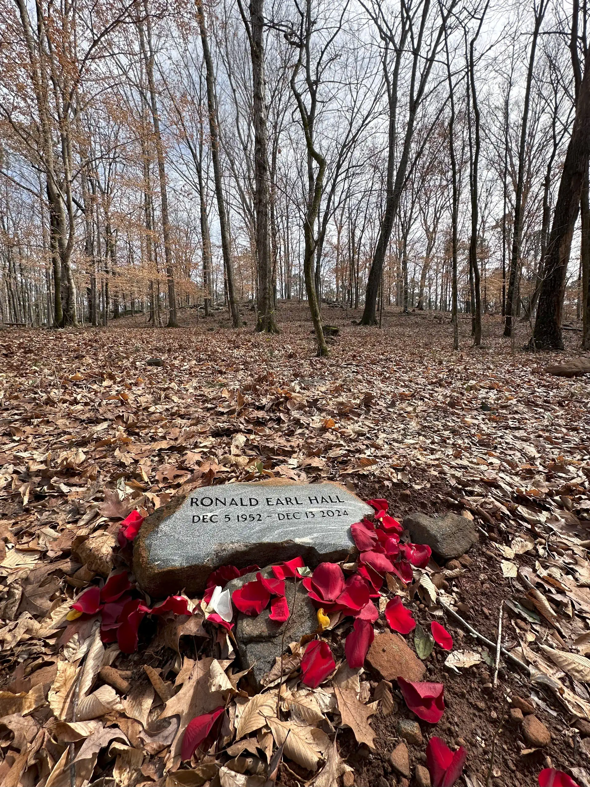 Ronnie Halls resting place surrounded by nature under the trees at Whispering Hills